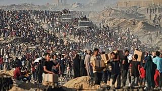 People carry sacks and boxes of food and humanitarian aid that was unloaded from a World Food Programme convoy that had been heading to Gaza City, 16 June, 2025