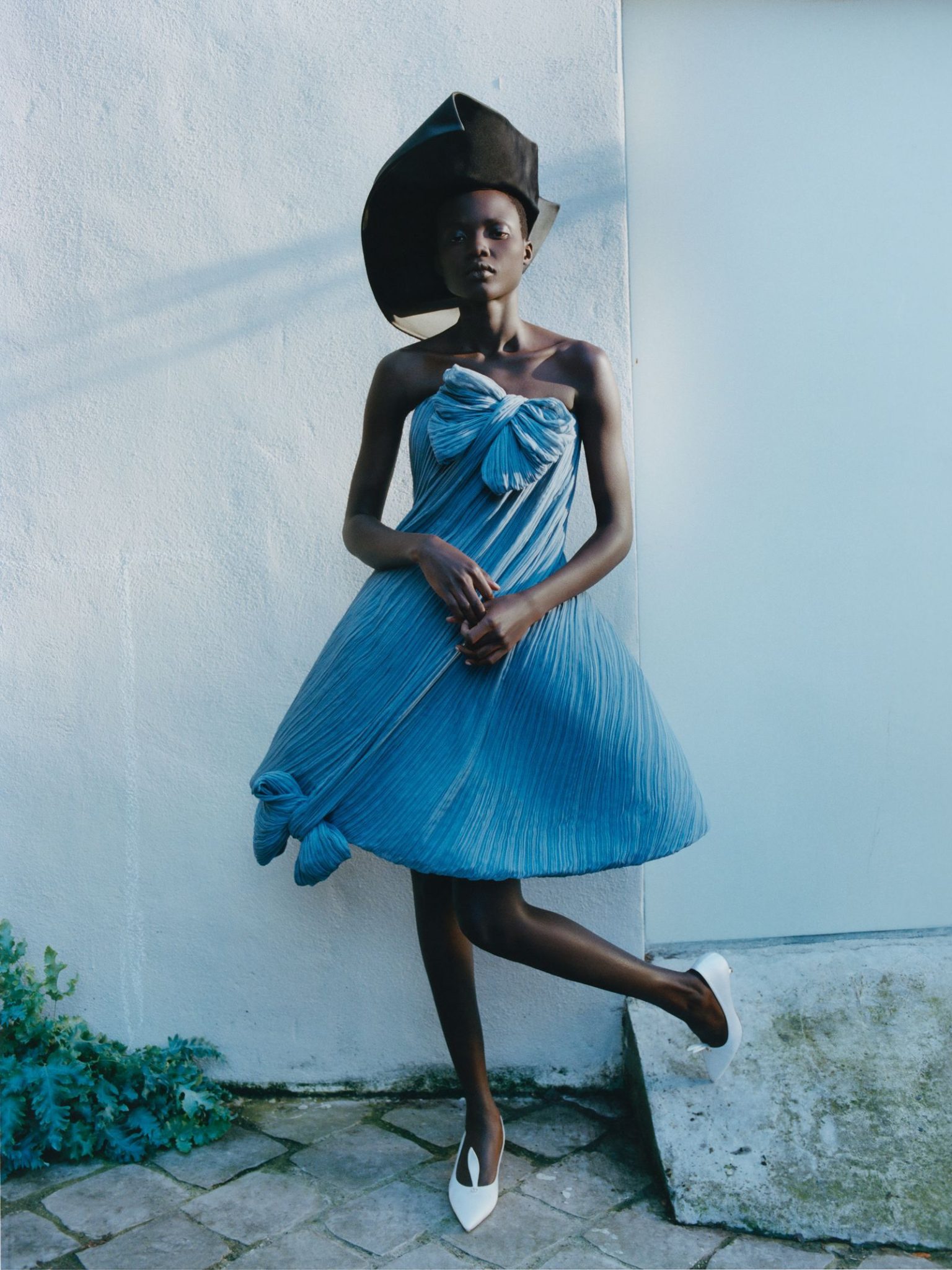 vo0326_dior_04 Image may contain Clothing Dress Adult Person Hat Sitting Formal Wear Face and Head