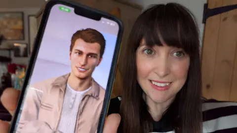 BBC Journalist Nicola Bryan is holding up her mobile showing her AI avatar George. Nicola has long dark hair with a fringe and is wearing a black and white striped jumper. George has short auburn hair, a beige open jacket and a white granddad collared top on underneath, Both are smiling at the camera.